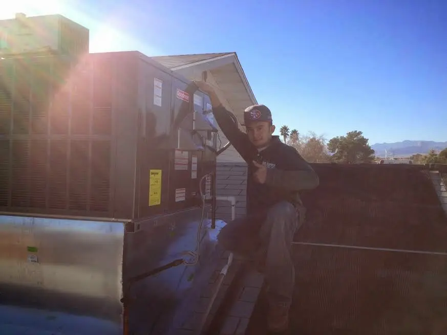HVAC technician performing AC Tune-Up on a rooftop unit in Fort Worth